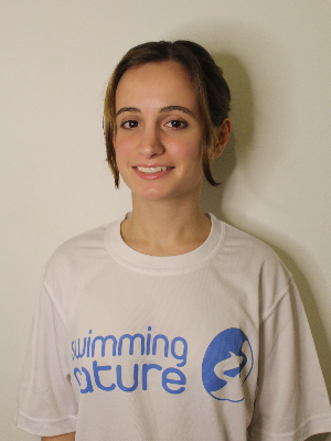 Head‑and‑shoulders portrait of swimming instructor Daniela in a Swimming Nature T‑shirt, smiling.