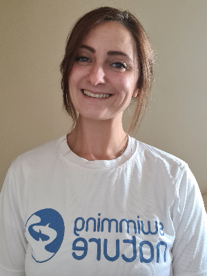 Head‑and‑shoulders portrait of swimming instructor Wesla in a Swimming Nature T‑shirt, smiling.