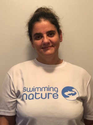 Head‑and‑shoulders portrait of swimming instructor Deborah in a Swimming Nature T‑shirt, smiling.