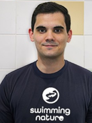 Head‑and‑shoulders portrait of swimming instructor Joao in a Swimming Nature T‑shirt, smiling.