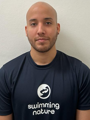 Head‑and‑shoulders portrait of swimming instructor Pablo Cesar in a Swimming Nature T‑shirt, smiling.
