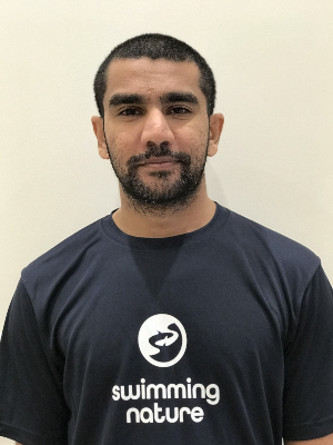 Head‑and‑shoulders portrait of swimming instructor Alam in a Swimming Nature T‑shirt, smiling.