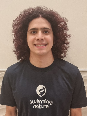 Head‑and‑shoulders portrait of swimming instructor Matheus in a Swimming Nature T‑shirt, smiling.