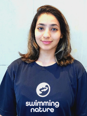 Head‑and‑shoulders portrait of swimming instructor Melina in a Swimming Nature T‑shirt, smiling.