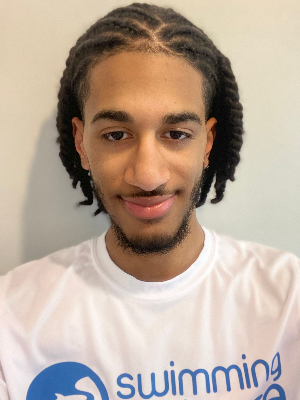 Head‑and‑shoulders portrait of swimming instructor Muhanad in a Swimming Nature T‑shirt, smiling.