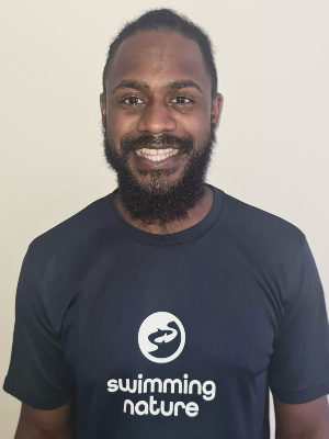 Head‑and‑shoulders portrait of swimming instructor Anton in a Swimming Nature T‑shirt, smiling.