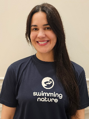 Head‑and‑shoulders portrait of swimming instructor Ingrid in a Swimming Nature T‑shirt, smiling.