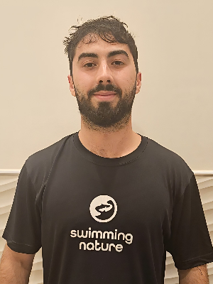 Head‑and‑shoulders portrait of swimming instructor Nuno in a Swimming Nature T‑shirt, smiling.