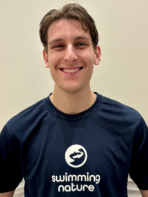 Head‑and‑shoulders portrait of swimming instructor Jeremy in a Swimming Nature T‑shirt, smiling.