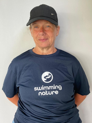 Head‑and‑shoulders portrait of swimming instructor Teresa in a Swimming Nature T‑shirt, smiling.