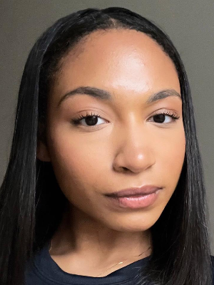 Head‑and‑shoulders portrait of swimming instructor Obenewa in a Swimming Nature T‑shirt, smiling.