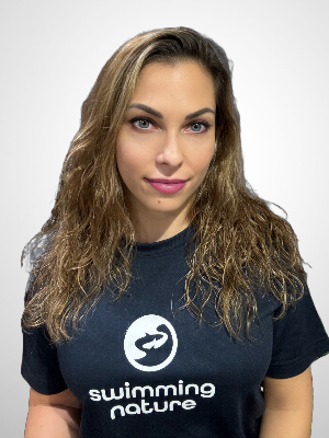 Head‑and‑shoulders portrait of swimming instructor Adrienn in a Swimming Nature T‑shirt, smiling.