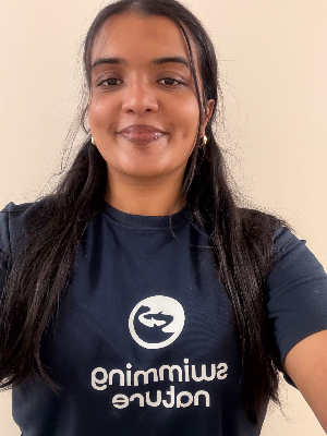 Head‑and‑shoulders portrait of swimming instructor Carolina in a Swimming Nature T‑shirt, smiling.