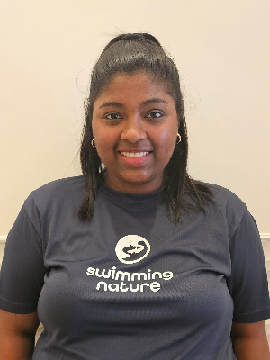 Head‑and‑shoulders portrait of swimming instructor Michela in a Swimming Nature T‑shirt, smiling.