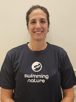 Head‑and‑shoulders portrait of swimming instructor Elodie in a Swimming Nature T‑shirt, smiling.