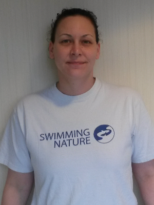 Head‑and‑shoulders portrait of swimming instructor Natalie in a Swimming Nature T‑shirt, smiling.
