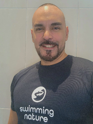 Head‑and‑shoulders portrait of swimming instructor Ruben in a Swimming Nature T‑shirt, smiling.