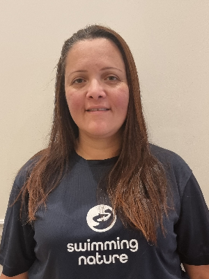 Head‑and‑shoulders portrait of swimming instructor Thais in a Swimming Nature T‑shirt, smiling.
